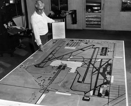 Dade County Port Authority Director A. B. Curry looks over Miami International Airport expansion plan drawings. 1950. Photo by Ralph Kestly. Miami News Collection, HistoryMiami. 1989-011-10041.