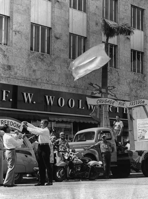 Grant Stockdale and group put up banners for The Crusade for Freedom campaign on Flagler Street. One of the Crusade’s missions was to provide funding for radio broadcasts to counter anti-United States propaganda. Parades and meetings were held across the United States, and citizens were given the opportunity to sign the Freedom Scroll. September 27, 1951. Ed Pierce, photographer. Miami News Collection, HistoryMiami. 1995-277-2881.