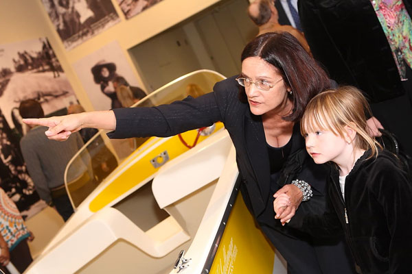 Member showing a child the museum exhibition