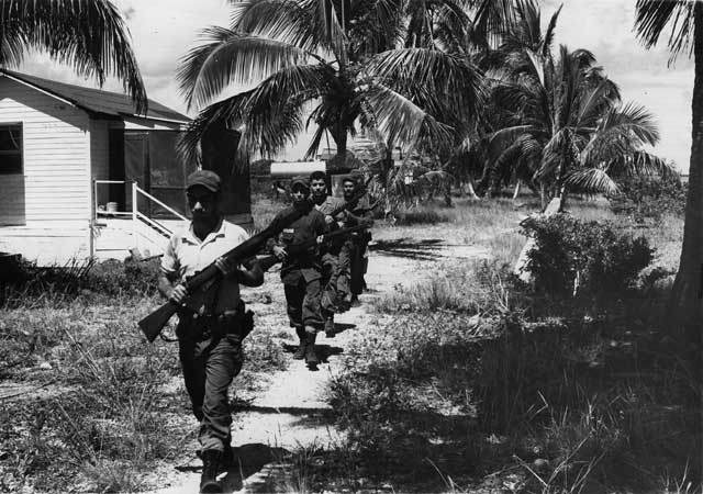 Anti-Castro Cuban exiles train on No Name Key. This was a preliminary training site; volunteers who made the grade went to other camps in the Everglades for more intensive training. The trainees lived in the old abandon homes shown at left. October 10, 1962. Miami News Collection, HistoryMiami. 1989-011-4599.