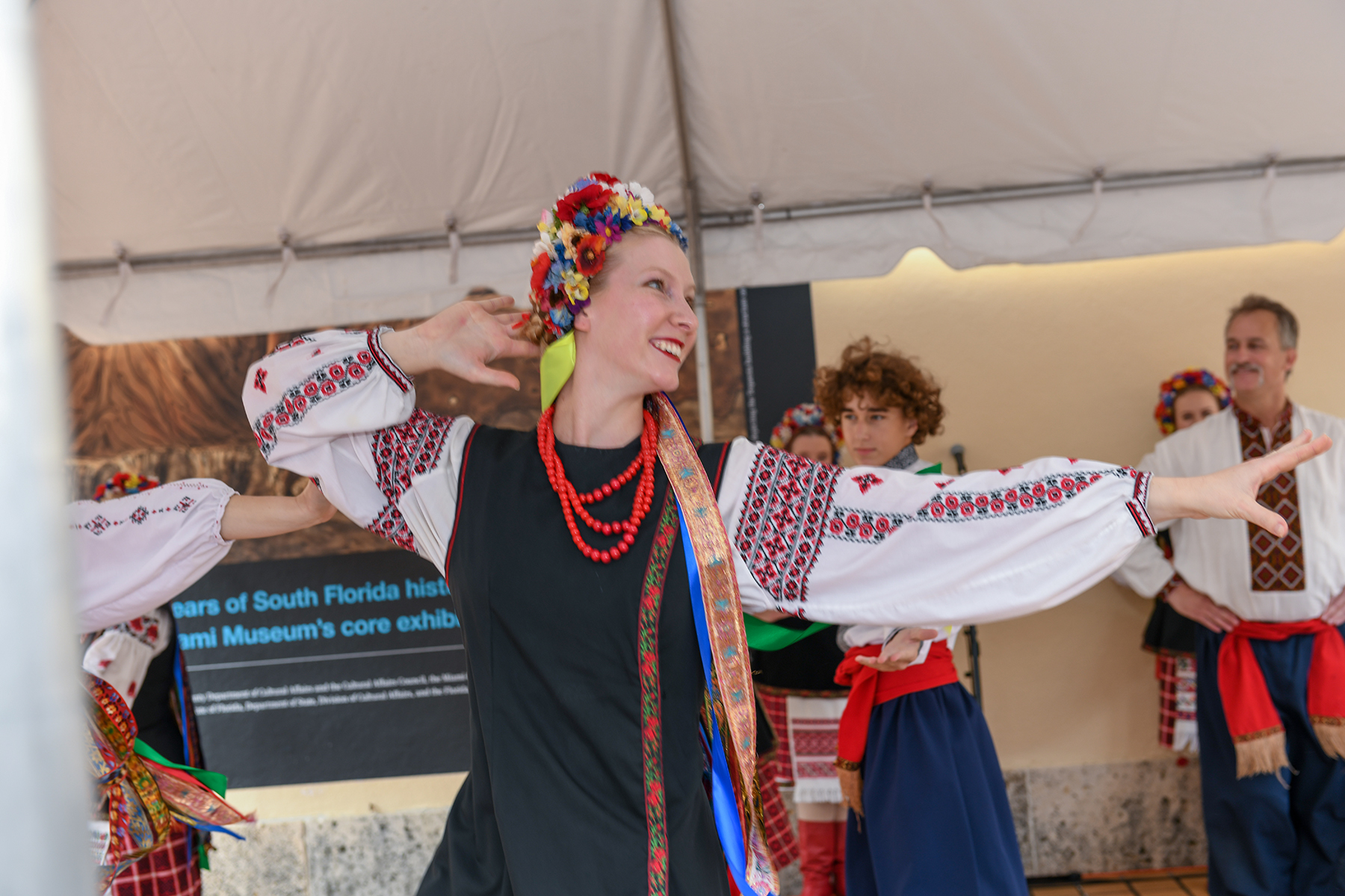 woman dances in traditional costume of flower headband and embroidered dress