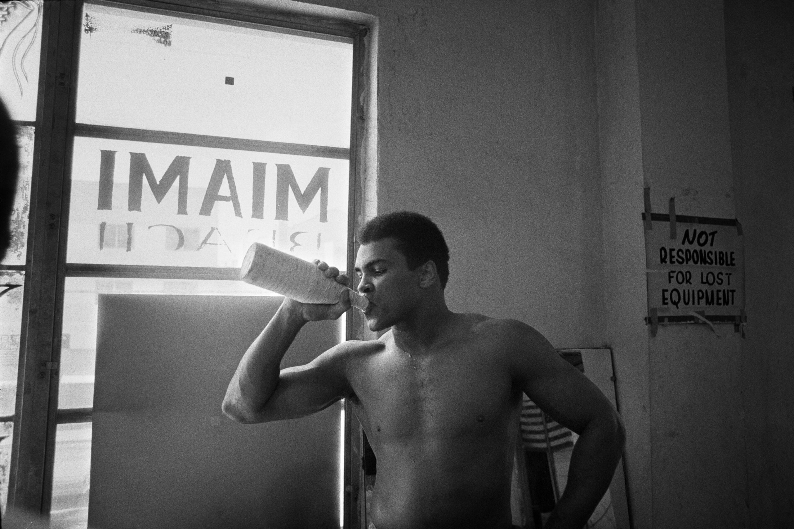 Muhammad Ali in gym drinking water