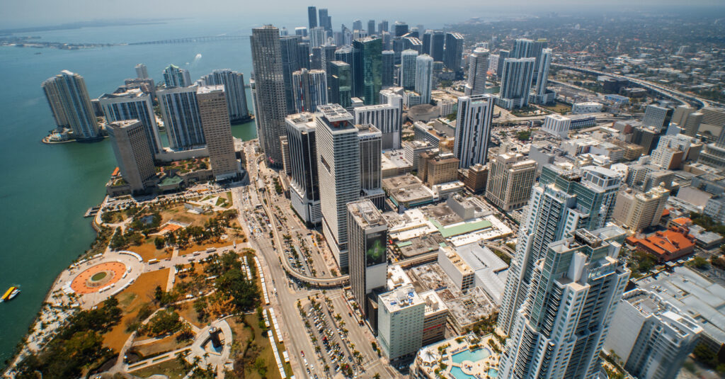Aerial image of Downtown Miami. Skyscrapers, streets, and Biscayne Bay are in view. Photo courtesy of the GMCVB – http://MiamiandBeaches.com
