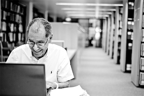 Dr. George seating in front of a laptop computer in the research center