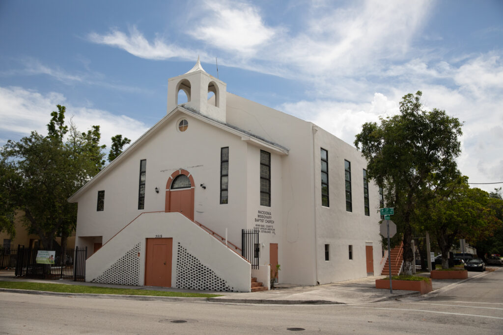A white church with beige doors sits on a corner. Photo courtesy of the GMCVB – http://MiamiandMiamiBeach.com