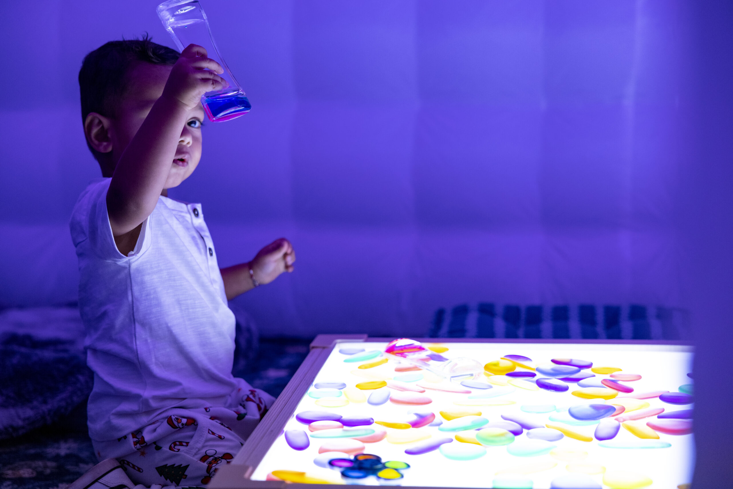 child playing with blocks in a dimly lit room.