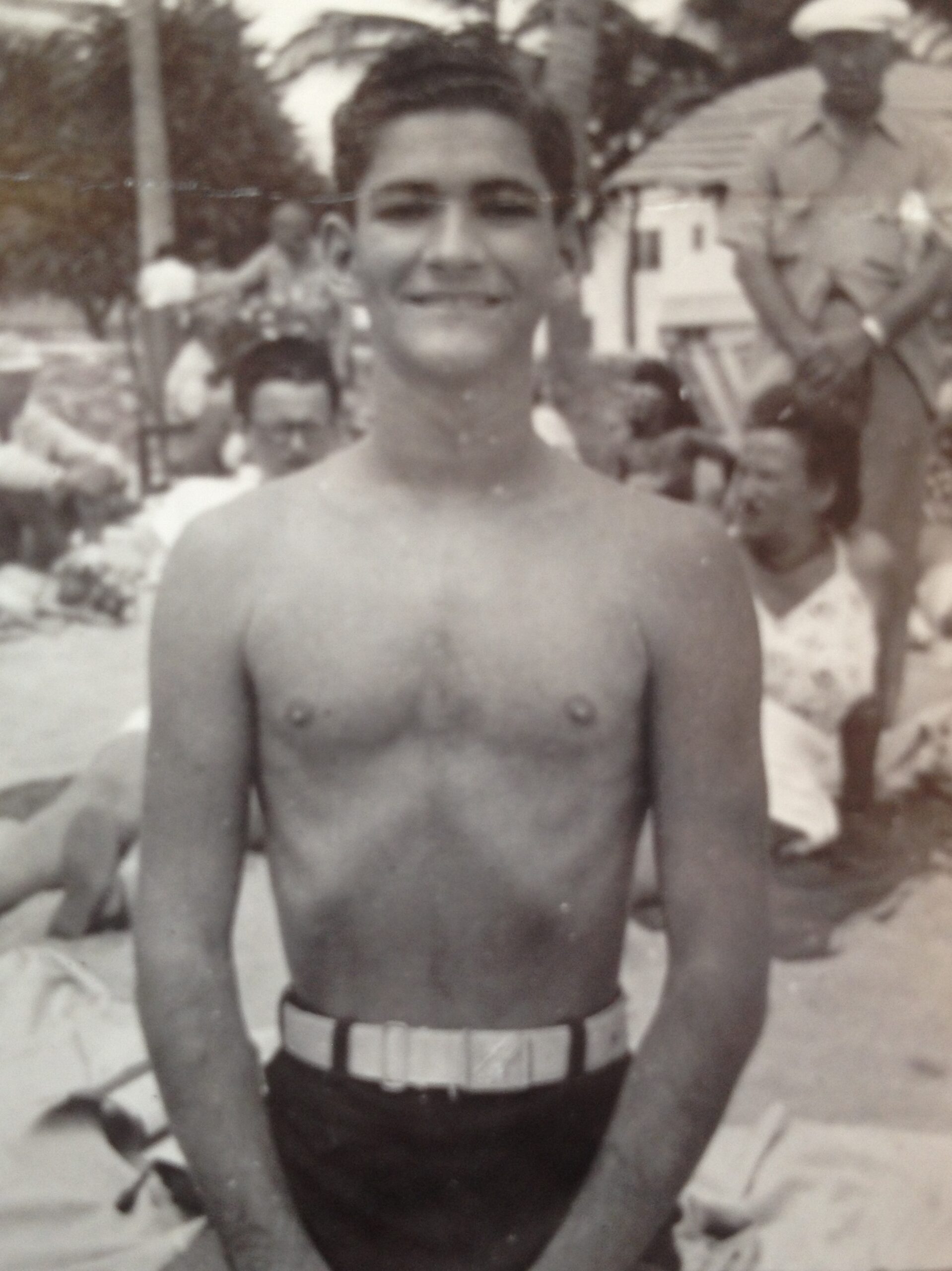 Black and white photo of a young teenager, Manny Zaiac, standing on the beach in 1948.