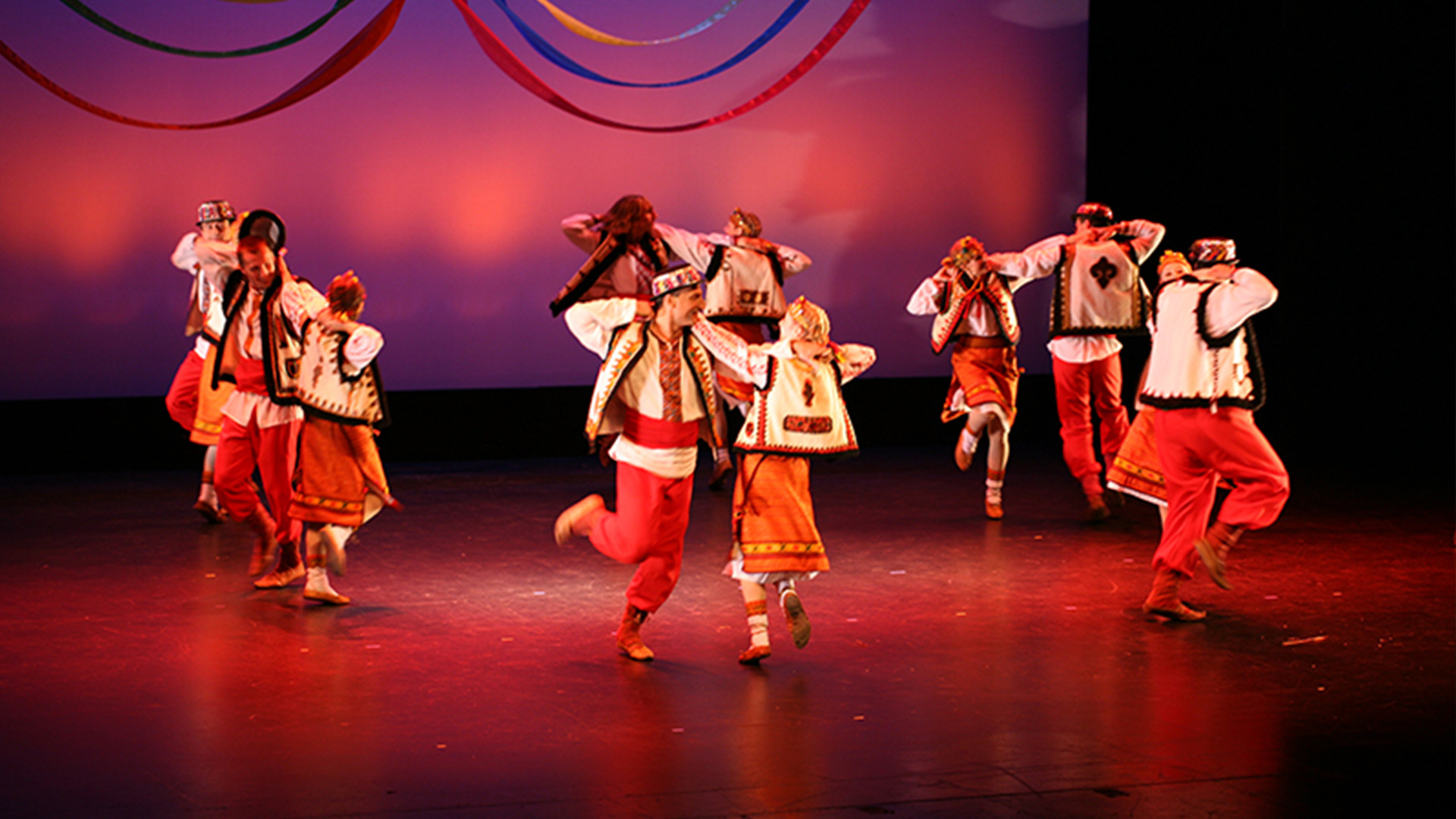 dancers perform on stage in pairs