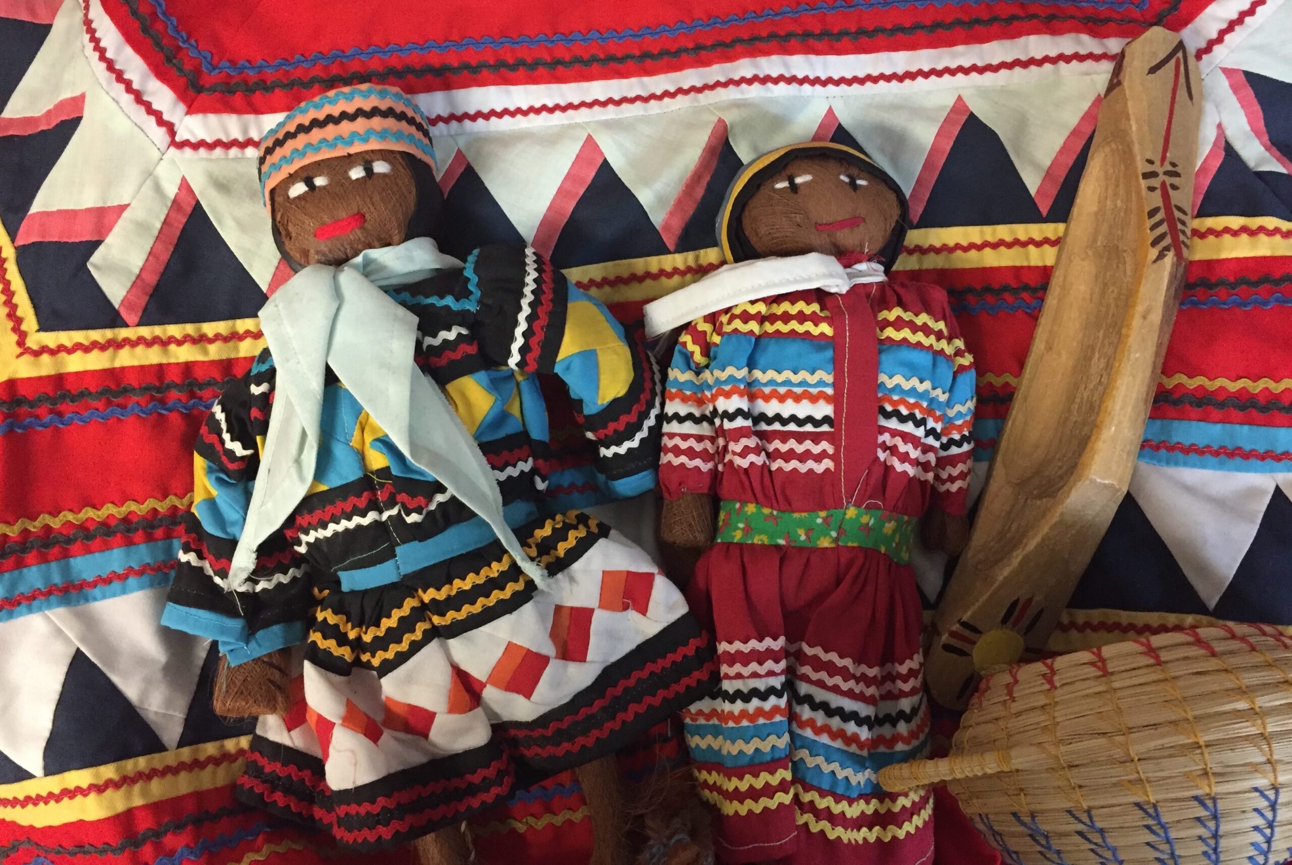 Two Seminole dolls with basket and canoe