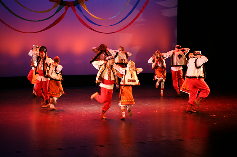 dancers perform on stage in pairs