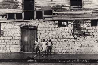 Maria LaYacona. Children in front of Old Gaol. 1986. 28 x 36 cm. Institute of Jamaica, 2006.23.14. American-born Maria LaYacona settled in Jamaica in the 1950s and became one of the country’s leading portrait photographers.