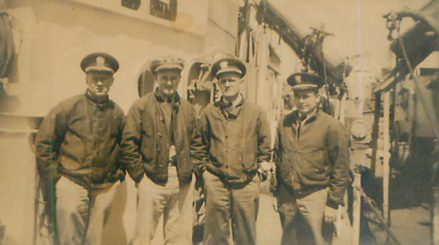 A photo from 1944 of four service men in jackets and hats.
