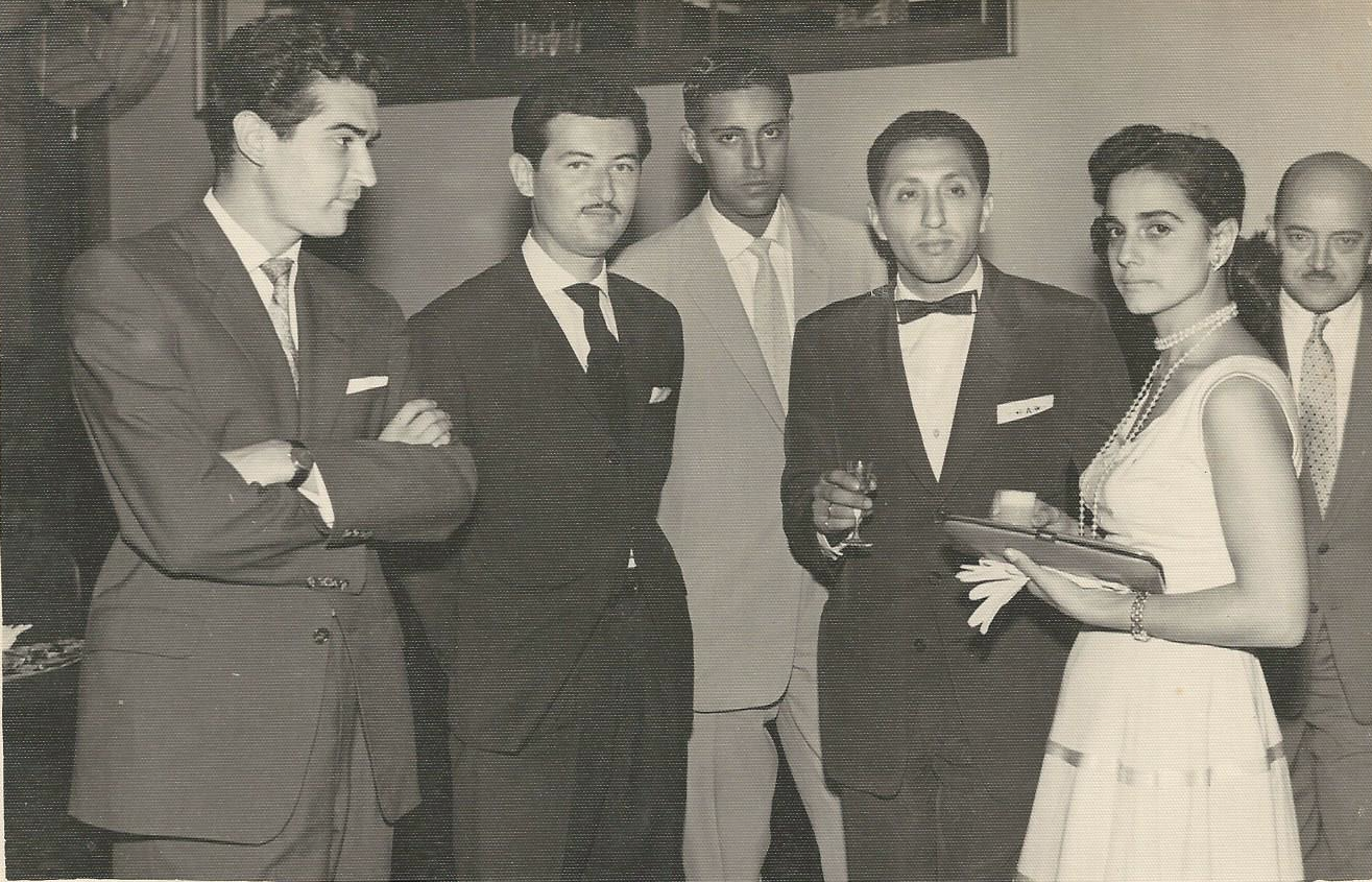 Black and white photo of 5 men and a woman, all dressed in formal attire.