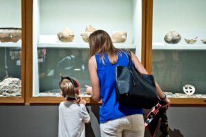 Visitors looking at archeological items in gallery.
