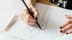 View from above of a person drawing a fashion sketch