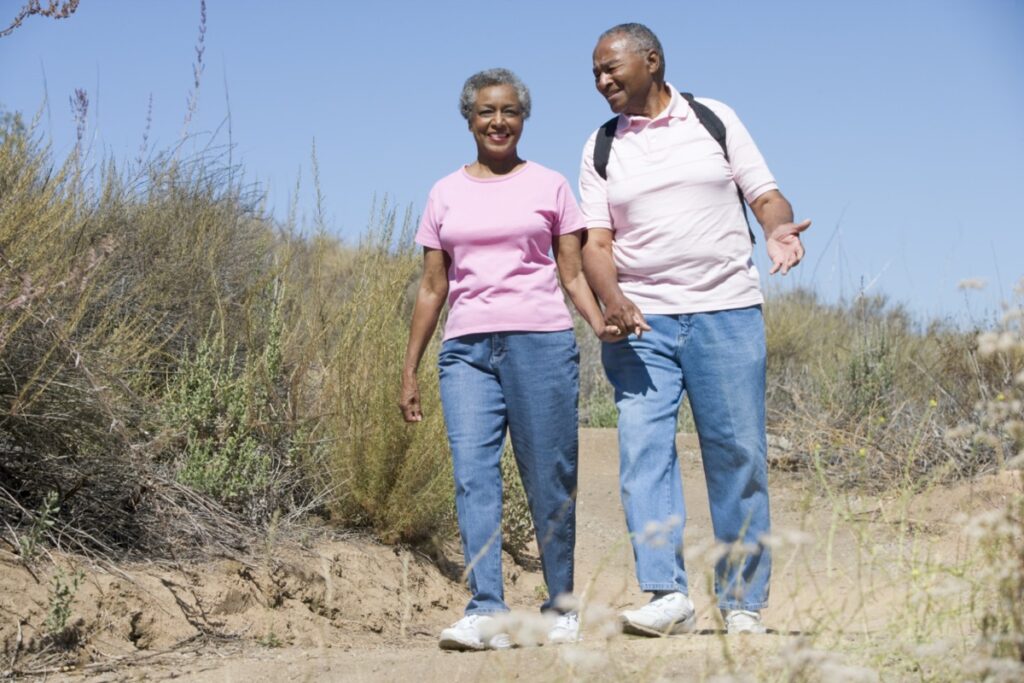 two older adults walking on a trail